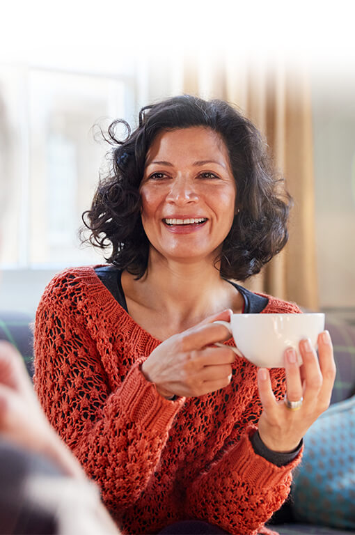 ReSound vrouw met een bak koffie tijdens een vrienden afspraak