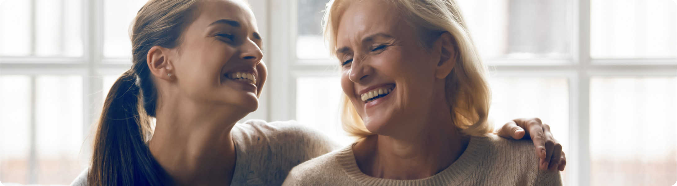 Twee vrouwen met gehoorapparaat in lachen samen