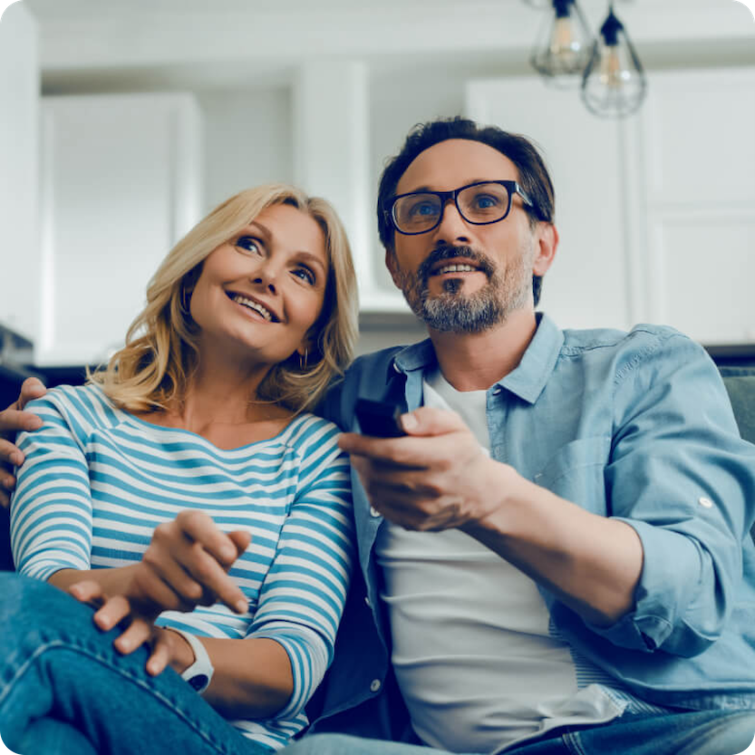 Man en vrouw op bank die televisie aan het kijken zijn 1