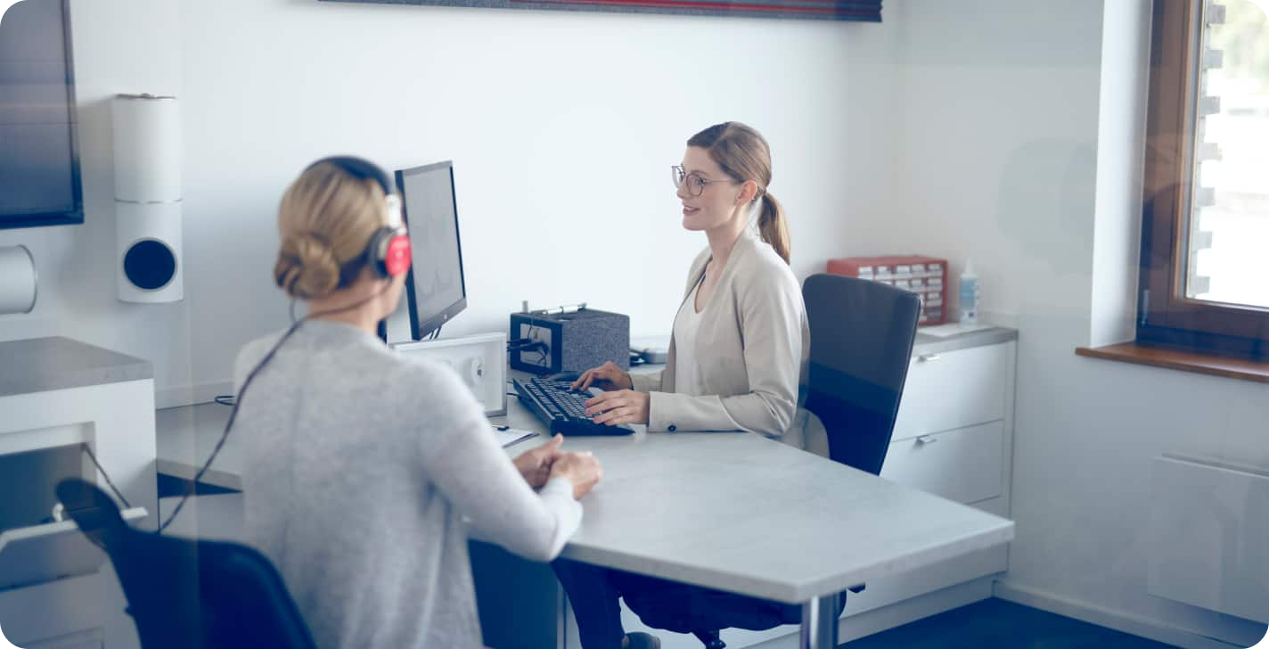 Vrouw die een gehoortest aflegt bij een audicien of KNO 1