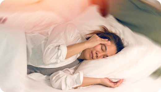 Vrouw met bruin haar ligt in bed met pijn aan haar oor