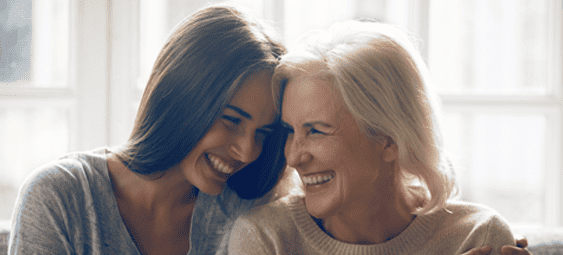 twee vrouwen zitten op de bank en lachen met elkaar